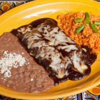 Enchiladas De Mole · 2 corn tortillas with shredded chicken. Topped with our famous mole sauce, topped with chees...