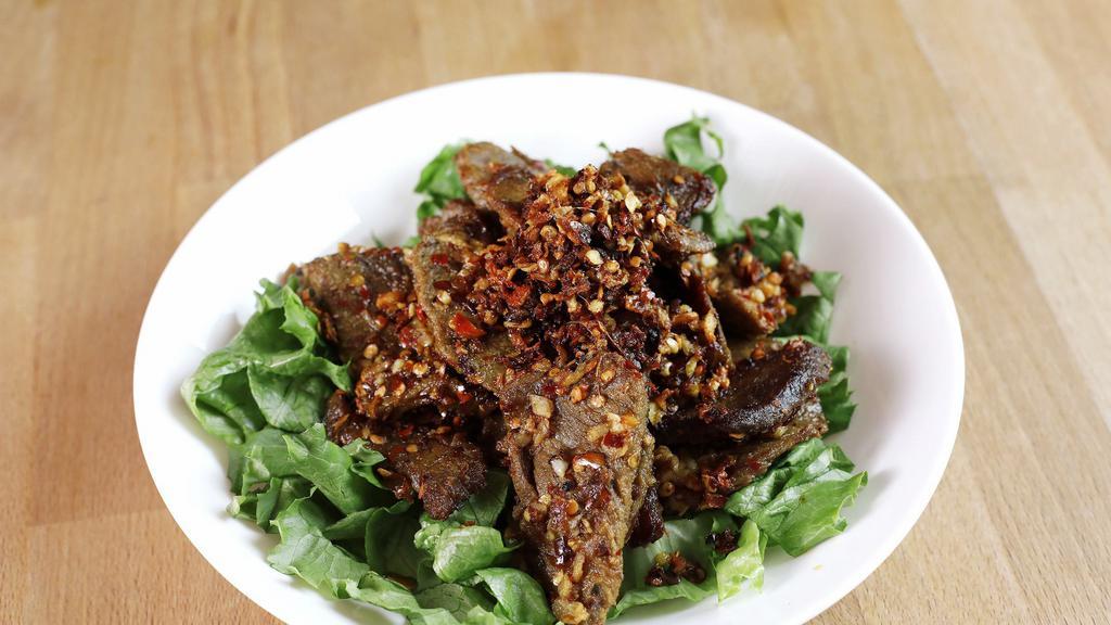 Spicy Beef Jerky · Thinly sliced beef with fried shallots and dried chili over shredded lettuce.