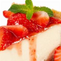 Strawberry Cheesecake · Fresh slice of cheesecake topped with cut strawberries.