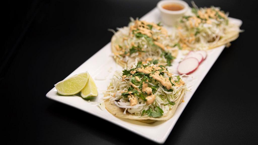 Fish Tacos · Grilled fish, topped with cabbage slaw, cilantro and serve with crema de chipotle.