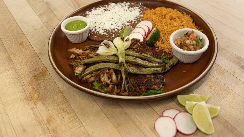 Pork Carnitas Plate  · Tender marinated and shredded slow roasted pork served with rice and beans. Served with rice, refried beans and salad.