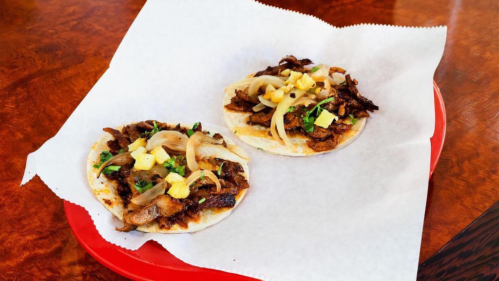 Jalisco Style Pastor Taco · Al pastor taco with grilled onions, cilantro, pineapple, and chipotle salsa.