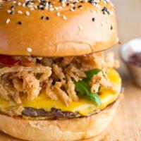 Texas Burger · Juicy beef patty with Swiss cheese, lettuce, BBQ sauce, onions, and bell peppers on a sesame...