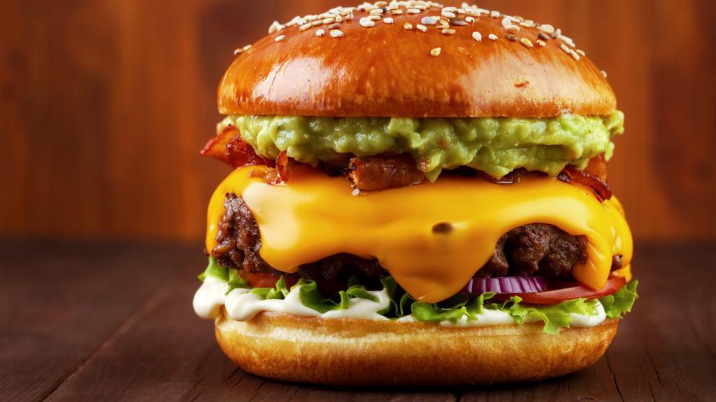 Avocado Cheeseburger · Juicy beef patty with creamy avocado, melted cheese, lettuce, tomatoes, pickles, onions, ketchup, and mustard on a sesame seed bun.