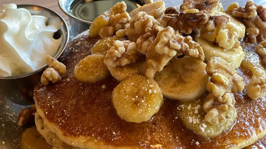 Pancake Banana Flambe · Stack of 3 pancakes topped with rum-caramelized & fresh sliced bananas & walnuts. Dusted with cinnamon & powdered sugar. Served with whipped cream & syrup.