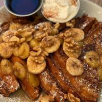 French Toast Banana Flambe · 4 pieces of brioche topped with rum-caramelized bananas, fresh banana slices, walnuts, sprin...
