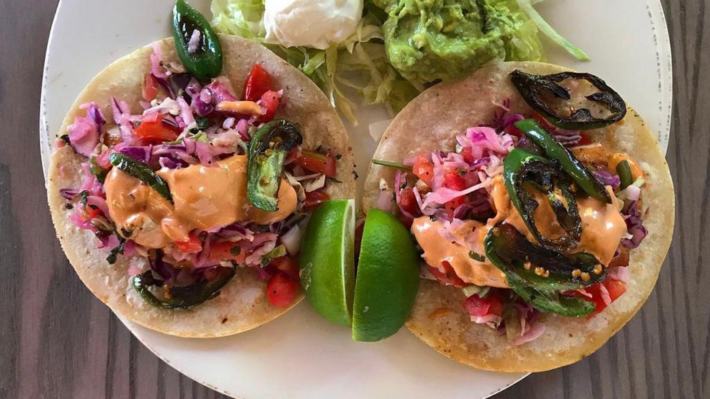Mahi-Mahi Tacos · Two corn tortillas generously stuffed with grilled mahi-mahi, guacamole, chipotle aioli & shredded cabbage. Served with sour cream, Pico de Gallo & a lime wedge. Your choice of green salad, a cup of soup or fruit.