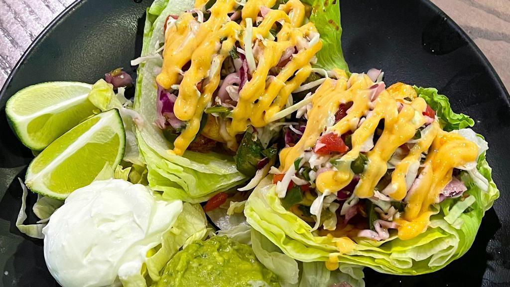 Keto Grilled Shrimp Tacos · Grilled shrimp,  guacamole, Chipotle aioli & shredded cabbage served on lettuce with sour cream, Pico de Gallo, a lime wedge & a side of green salad.