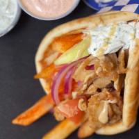 b. Pork Pita Wrap · Thin slices of seasoned pork, served on a warm pita bread filled with fries, tomatoes, onion...