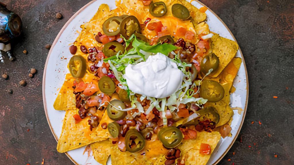 Supper Nachos · Tortilla chips overloaded with cheese, pico de gallo, pickled jalapeños, refried beans, sour cream, our secret salsa, and your choice of protein.