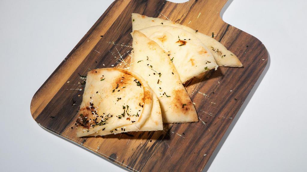 Kulcha Naan · One piece of buttered naan, topped with sesame seeds and mint. Contains gluten, dairy, soy, and eggs. We cannot make substitutions.