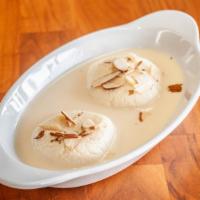 Rasmalai · Rasmalai consists of soft paneer balls immersed in chilled creamy milk topped up with nuts.