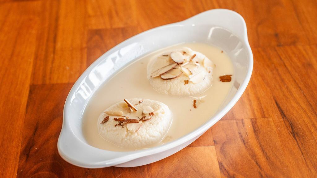 Rasmalai · Rasmalai consists of soft paneer balls immersed in chilled creamy milk topped up with nuts.