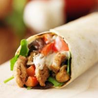 The Chicken Shawarma Wrap · Sizzling strips of chicken shawarma, lettuce, tomatoes, onions, tzatziki and tahini sauce wr...