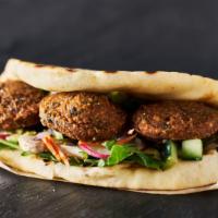 The Falafel Wrap · Classic falafel wrap with crispy chickpeas, lettuce, diced tomatoes, onions, tzatziki and ta...