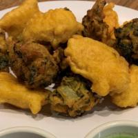 Vegetable Pakora · Vegan. Five pieces. Cabbage, onion, potato mixed golden fried vegetable served with mint sau...