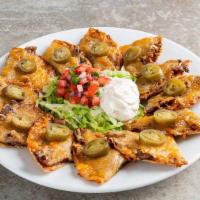 Classic Nachos With Beef · Beef, shredded cheese, black beans, jalapeños, Skillet Queso with beef. Served with pico & s...