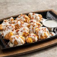 Loaded Boneless Wings · Smothered in white queso, shredded cheese, bacon. Served with house-made ranch.