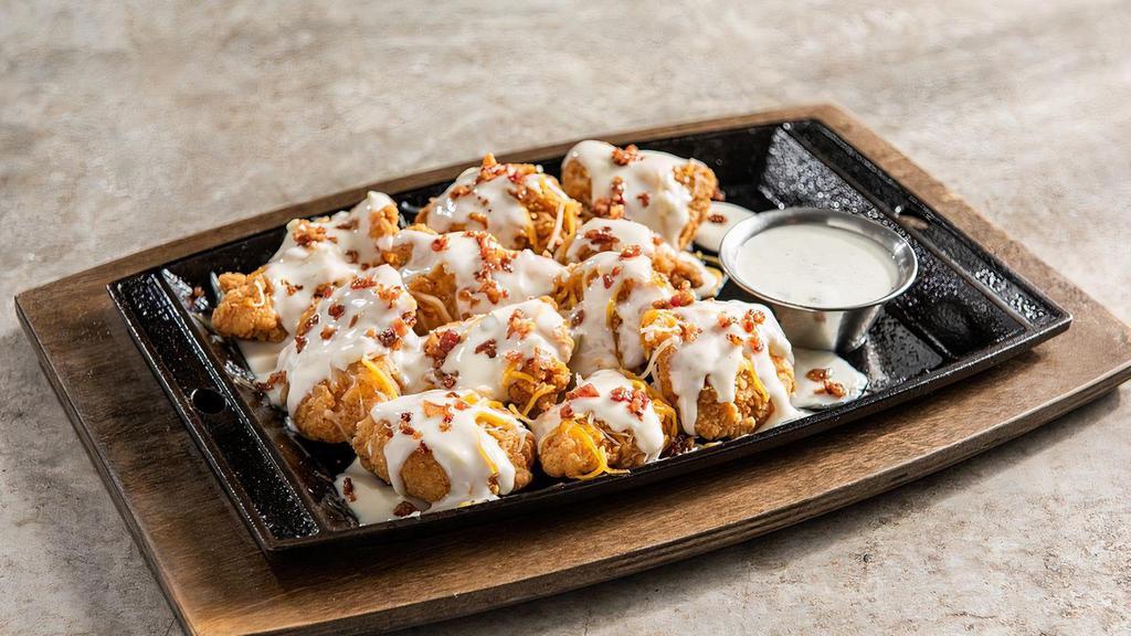 Loaded Boneless Wings · Smothered in white queso, shredded cheese, bacon. Served with house-made ranch.