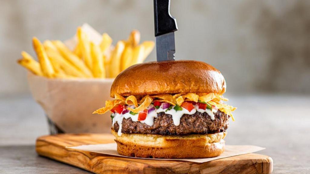 Queso Burger* · Say “cheese!” This half-pound patty comes smothered in white queso, crunchy tortilla strips & pico.