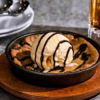 Skillet Chocolate Chip Cookie · Topped with vanilla ice cream, hot fudge.