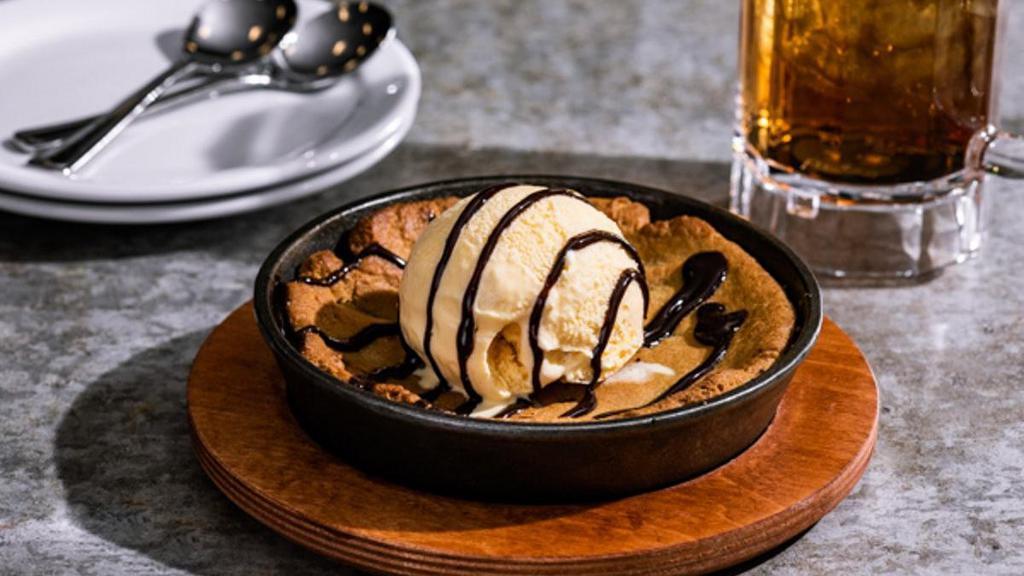 Skillet Chocolate Chip Cookie · Topped with vanilla ice cream, hot fudge.