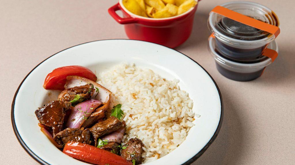 Lomo Saltado Tenderloin · A chinese tenderloin beef stir fry with a Peruvian twist. Comes with sauteed tomatoes, red onions, yellow chili, cilantro, spring onions, soy-oyster sauce and a side of fries. Accompanied either by quinoa or rice with giant corn.