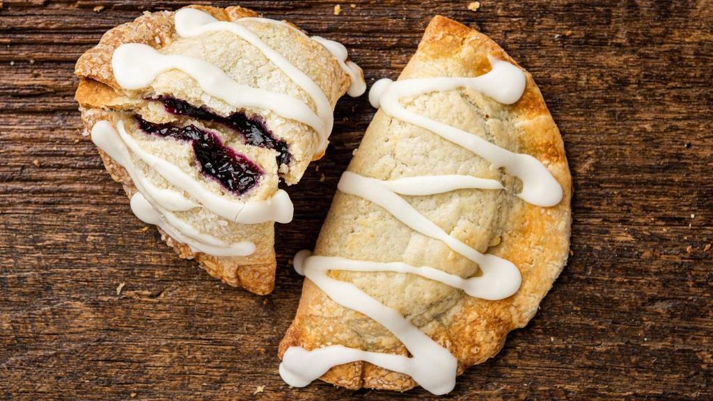 Blueberry Lemon Hand Pie · Flaky pie crust with blueberry filling, a touch of lemon zest and tart lemon frosting to top it off.