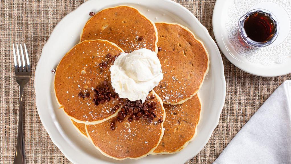 Chocolate Chip Pancakes · Chocolate chip buttermilk batter topped with chocolate chips & a sprinkle of powdered sugar. Served with a side of homemade whipped cream & maple syrup.