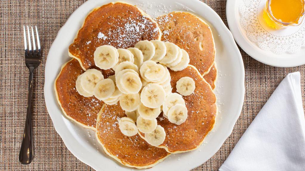 Fresh Banana Pancakes · Our buttermilk premium pancakes filled with diced fresh bananas, served with whipped butter and hot tropical syrup, dusted with powdered sugar. (cooked with peanut oil).