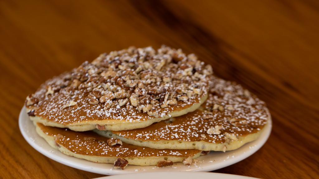 Fresh Georgia Pecan Pancakes · Filled and topped with hot toasted pecans, lightly dusted with powdered sugar, served with whipped butter and hot tropical syrup. (cooked with peanut oil).