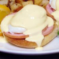 Eggs Benedict · An English muffin, Canadian bacon and poached eggs topped with hollandaise sauce and shredde...