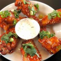 Korean Chicken Wings · Served with scallions, toasted sesame seeds, and cilantro and lemon blue cheese dip.