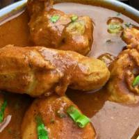 Chicken Curry · Boneless chicken cooked with tomatoes, onions, chili, mustard seeds, and fresh curry leaves.