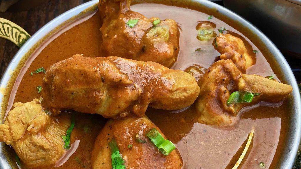 Chicken Curry · Boneless chicken cooked with tomatoes, onions, chili, mustard seeds, and fresh curry leaves.