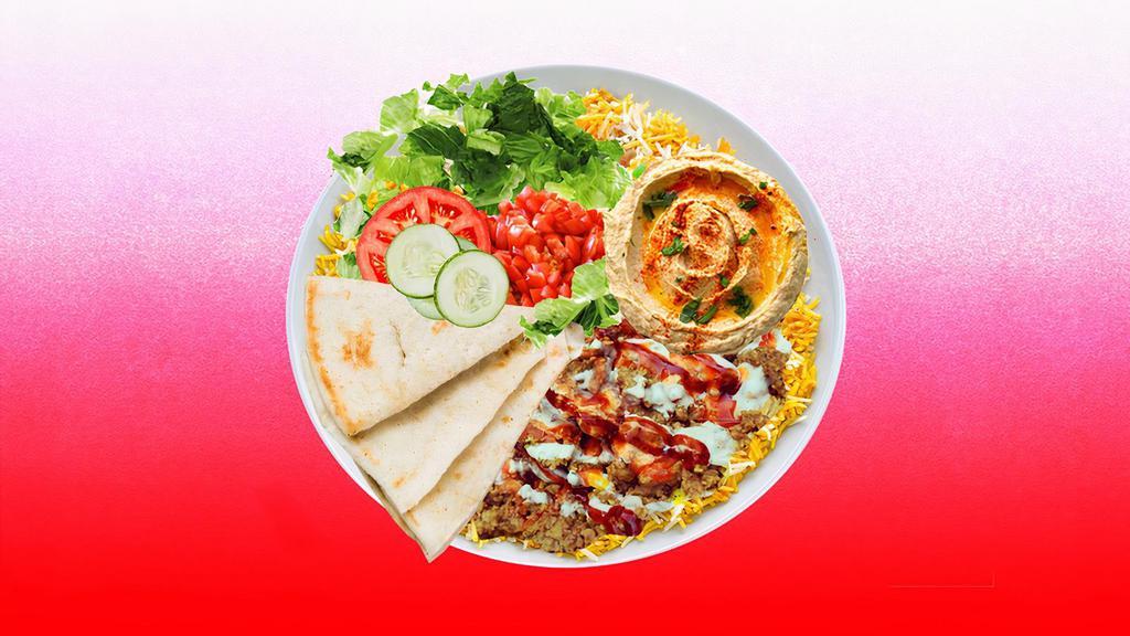 Spicy Beef Shawarma Hummus Platter · Juicy beef shawarma over hummus and topped with spicy red sauce.  Served with cucumber & tomato salad, leafy greens, white sauce, and pita.