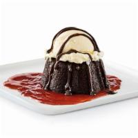 Gooey Chocolate Brownie Cake · Chocolate brownie cake with hot fudge and strawberry purée, served à la mode.