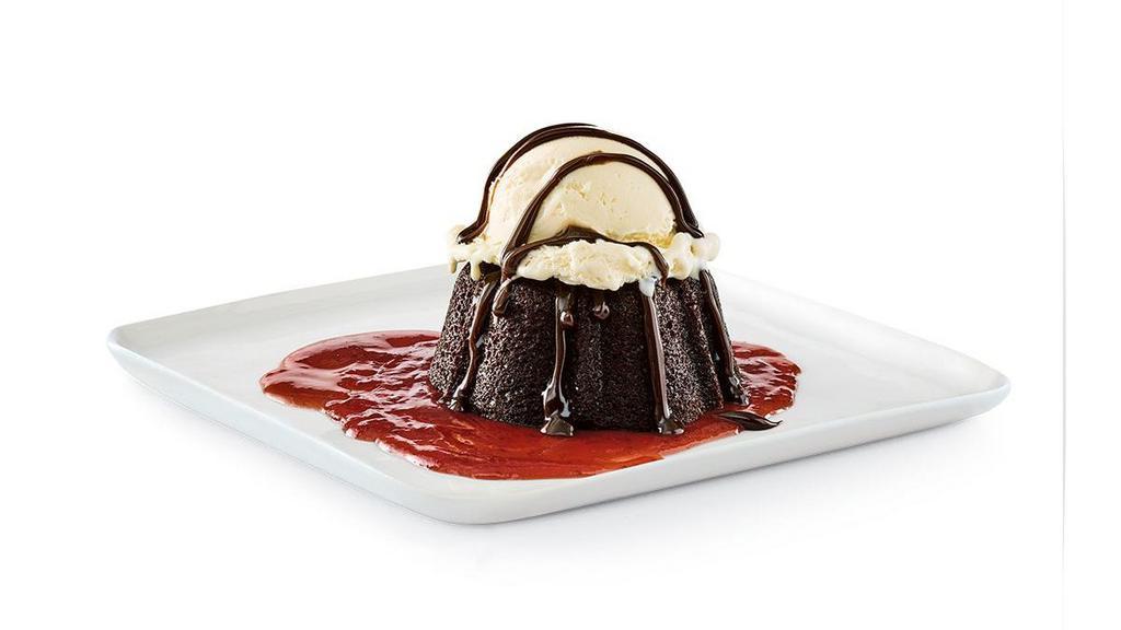 Gooey Chocolate Brownie Cake · Chocolate brownie cake with hot fudge and strawberry purée, served à la mode.