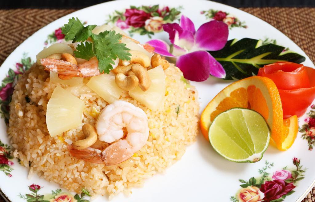 Pineapple Fried Rice · Thai style fried rice with chicken, shrimps, pineapple, white onion and cashew nut topped with cilantro and cucumber.