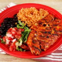 Pechuga al  Achiote · Fresh chicken breast marinated in a blend of achiote and spices; served with rice, beans, an...