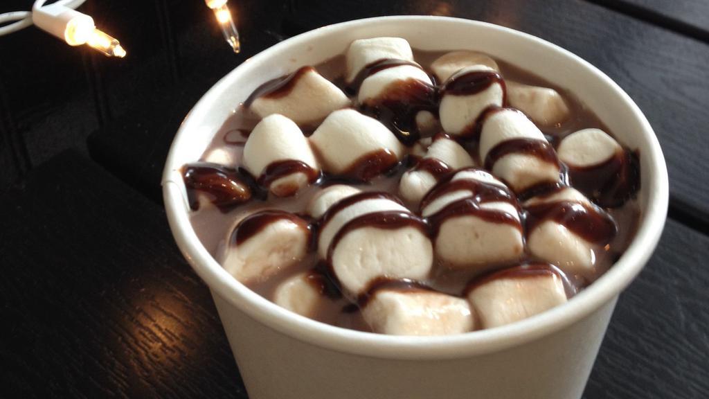 Oat Milk Hot Chocolate · Our hot chocolate is made with oat milk and topped with mini marshmallows and chocolate sauce.