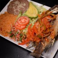 Mojarra a la Diabla · Whole fried fish with bell pepper, onions, tomato, hot sauce on the top with rice, beans, pi...