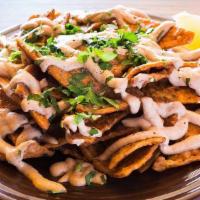 Totopos · Totopos tossed in a creamy salsa roja and cashew nacho cheese and topped with cilantro, lemo...
