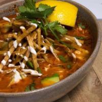 Pozole · Hominy stew with ancho chile broth. Avocado, cabbage, cashew cream & tortilla strips.