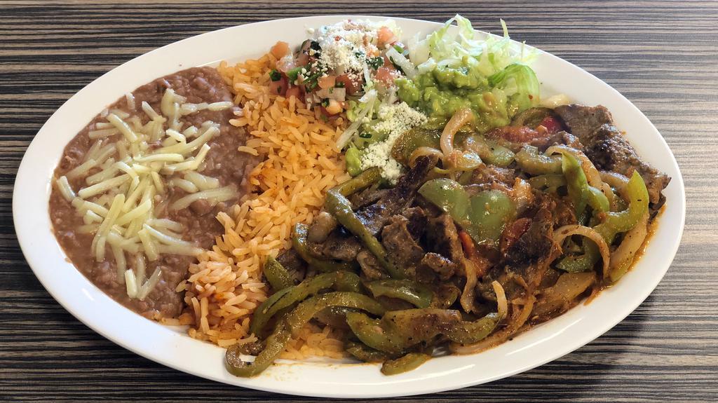 Fajitas · Steak, Chicken or Pork sautéed with onions and bell peppers with rice and beans.