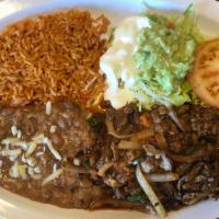 Bistec Ranchero Platillo · Steak with onions, tomato, jalapeños with a side of rice and Beans.