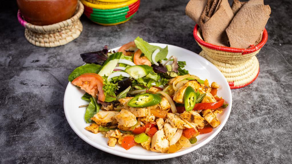 Chicken Tibs · Chicken breasts marinated in native Ethiopian spices . Consequently, it is stir with fried onion, tomato, garlic and berbere. Served with Injera or Yellow Rice.