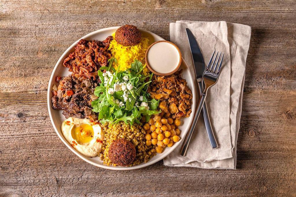 Double Protein Grain Bowl · Mean protein fix with chicken shawarma, steak shawarma, and falafel with your choice of grains. Comes with sumac cauliflower, garbanzo beans, hummus, feta cheese, wild arugula and tahini sauce.