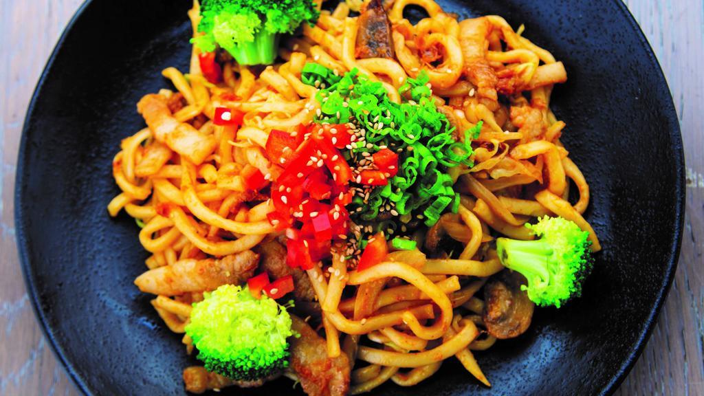 Miso Yaki-Udon · Thick, chewy udon noodles stir-fried with pork belly in our special miso-based sauce. Includes sliced mushrooms, onions, broccoli, shredded cabbage, chopped red bell peppers, and green onions. Finished with bonito flakes and a dash of sesame seeds.