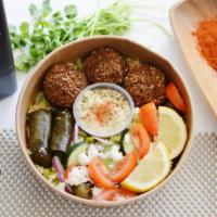 Falafel Bowl  · Rice over greek salad with tomatoes, feta cheese, and olives on top accompanied with dolmas,...